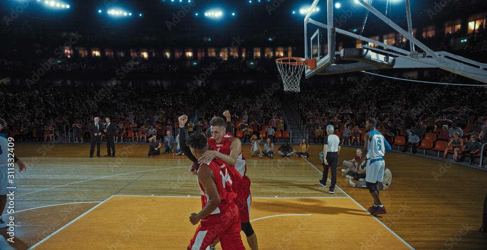 Basketball players on big professional arena during the game. Tense moment of the game. Celebration