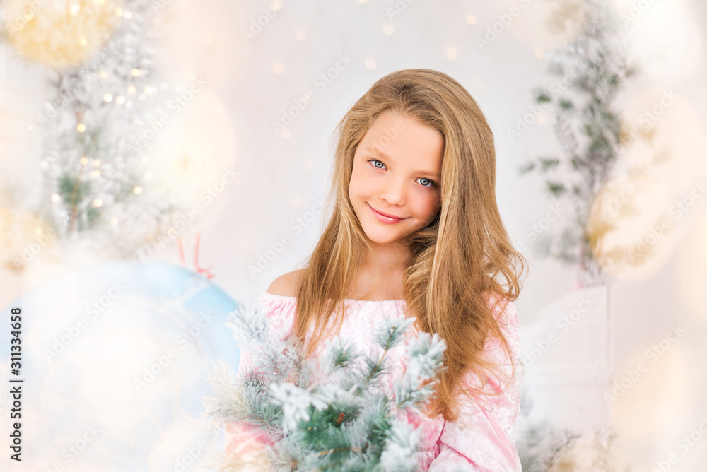 portrait of a beautiful baby girl with blonde hair. The new year atmosphere. Elegant Christmas tree. Lights. Magic postcard portrait of a beautiful baby girl with blonde hair. The new year atmosphere. Elegant Christmas tree. Lights. Magic postcard