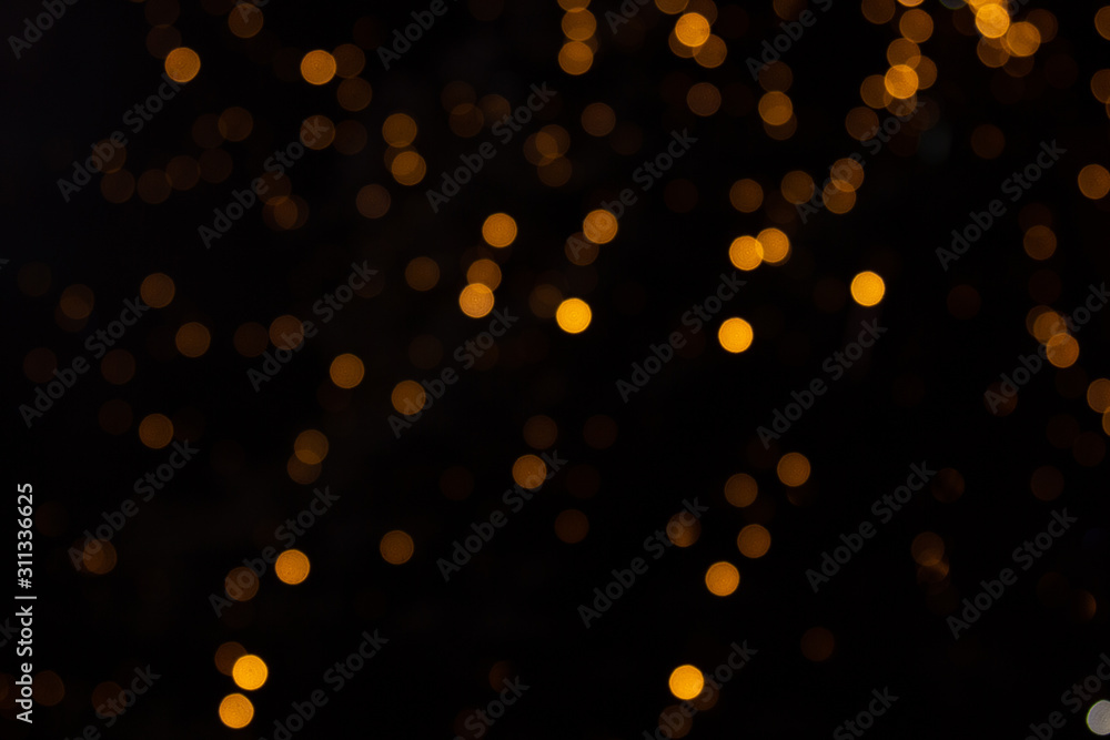 Golden abstract yellow, orange bokeh lights isolated on black background with copy space. Holiday and Christmas season concept, graphic resources, greeting card. wallpaper. Multi-colored lights.