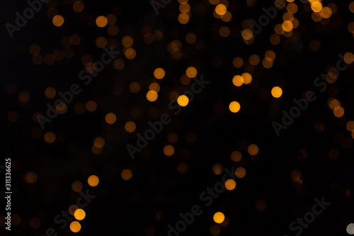 Golden abstract yellow, orange bokeh lights isolated on black background with copy space. Holiday and Christmas season concept, graphic resources, greeting card. wallpaper. Multi-colored lights.