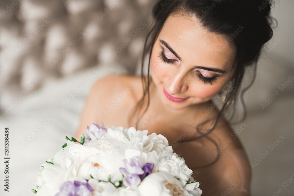Gorgeous bride in robe posing and preparing for the wedding ceremony face in a room Gorgeous bride in robe posing and preparing for the wedding ceremony face in a room