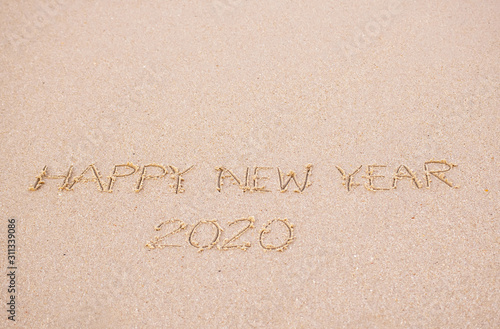 Happy New Year's 2020 writing in the sand beach in the morning, appropriate the Backdrop idea copy space