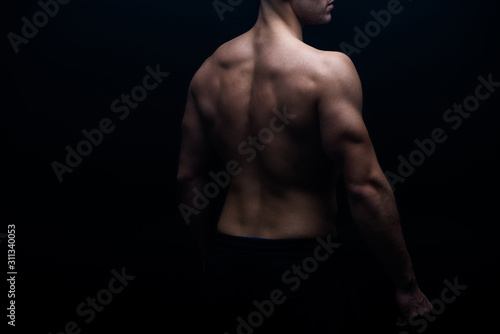 partial view of sexy bodybuilder with muscular back isolated on black