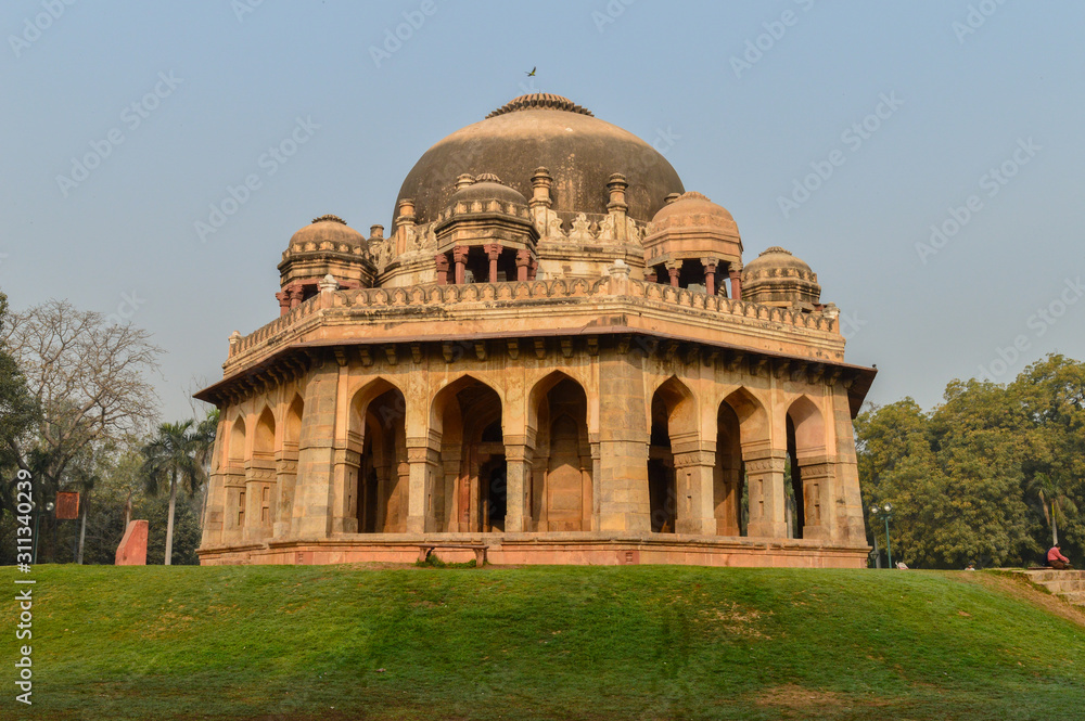 A Tomb of sikandar lodhi monument at lodi garden or lodhi gardens in a city park from the side of the lawn at winter foggy morning.