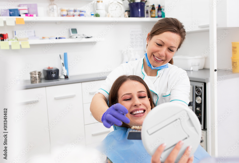 Young woman having teeth examined by female dentist in dental office. Young woman having teeth examined by female dentist in dental office.