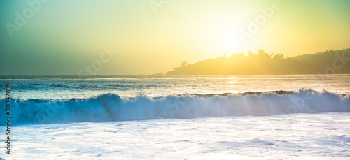 Sunset over Californian beach with crushing waves and white frothing sea at Pacific Coastal Highway No. 1 from San Francisco to Los Angeles, California, United States of America