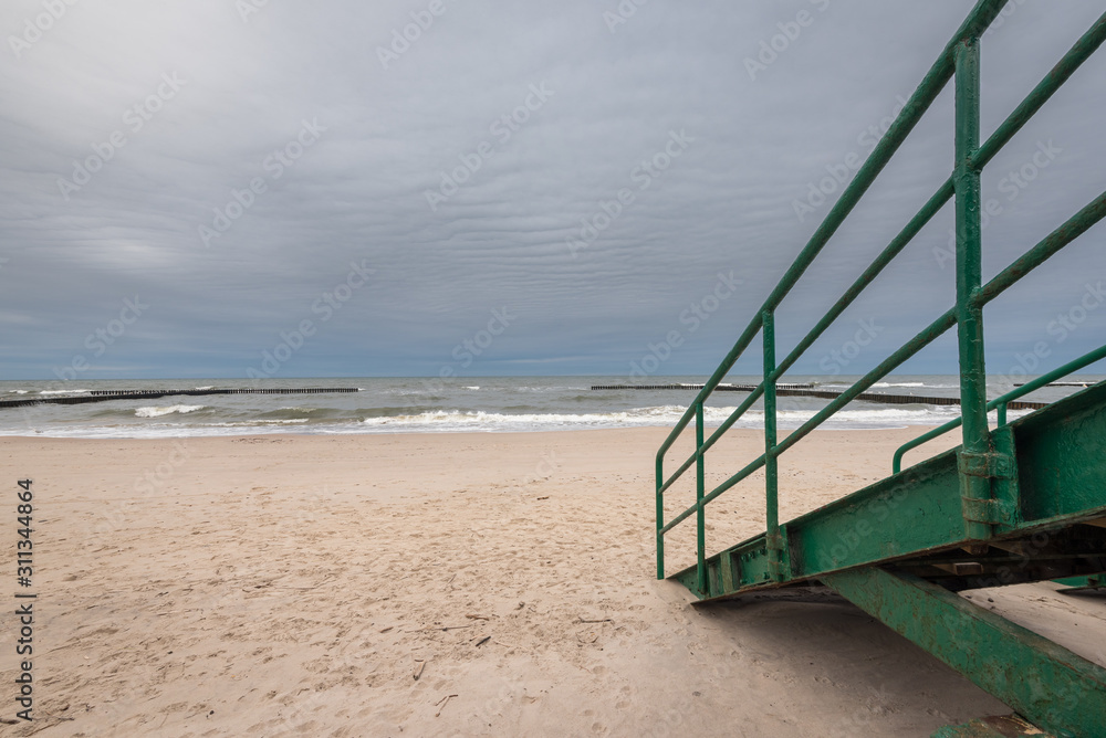 Stairs to an empty beach on a rainy day on a cloudy day. Baltic Sea, Poland