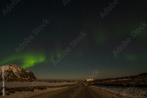 winter landscape with aurora, sea with sky reflection and snowy mountains. Nature, Lofoten Aurora borealis.