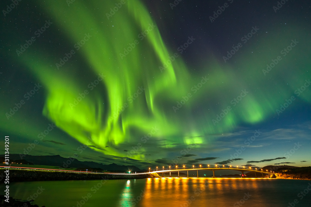 Dramatic aurora borealis, polar lights, over mountains in the North of Europe - Lofoten islands, Norway