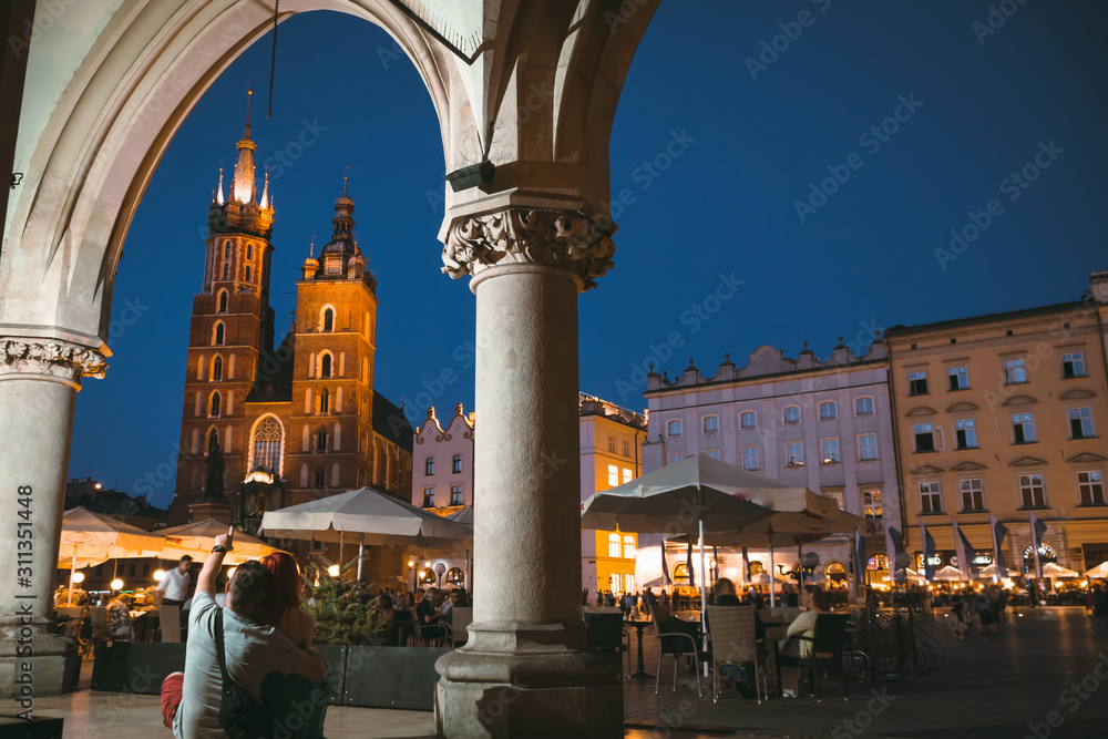 Happy couple in love on the street near the Wavel castle in Krakow, have a rest and enjoy the evening view of the city. Poland. Tourism travel concept, copy space. Man and woman, romantic