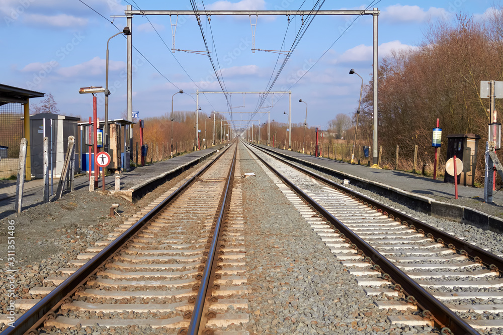 Perspective view on two railway tracks in a rural scene in Belgium Flanders