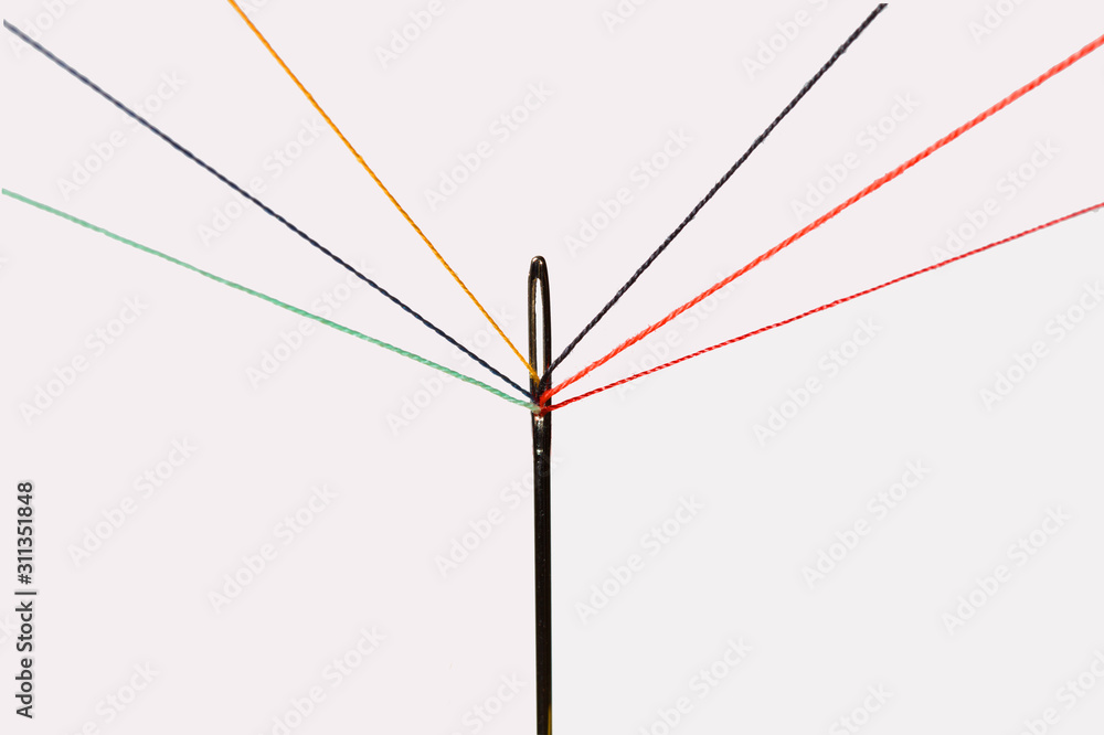 Fototapeta premium multiple colorful threads passing through the eye of a needle