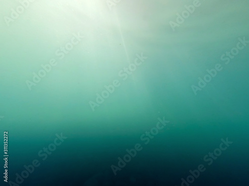 Marine underwater background. Sun rays under water.