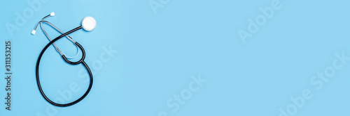 Glass bottle and glass with clear water on a blue background with a question mark. Concept of health and beauty, water balance, thirst, heat, summer, choice. Flat lay, top view. Banner