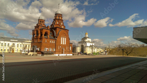 View of the town square in the sunlight with the old churches of red and white stone
