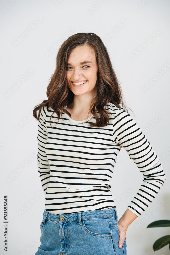 Portrait of a cheerful brunette with long voluminous hair, casually dressed. Portrait of a cheerful brunette with long voluminous hair, casually dressed.