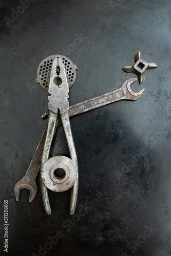 Repair tools form a symbolic composition. Pliers creative. Metal creative. Steel tools decor. Hands outstretched. Fake saint. He speaks his ideas.