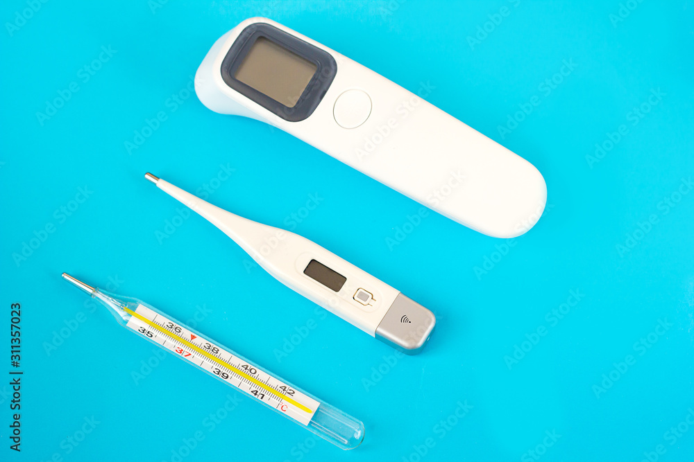 digital thermometer mercury and non-contact on a blue background, progress in medicine digital thermometer mercury and non-contact on a blue background, progress in medicine