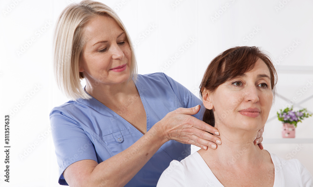 Physiotherapist working with middle aged patient in clinic Physiotherapist working with middle aged patient in clinic