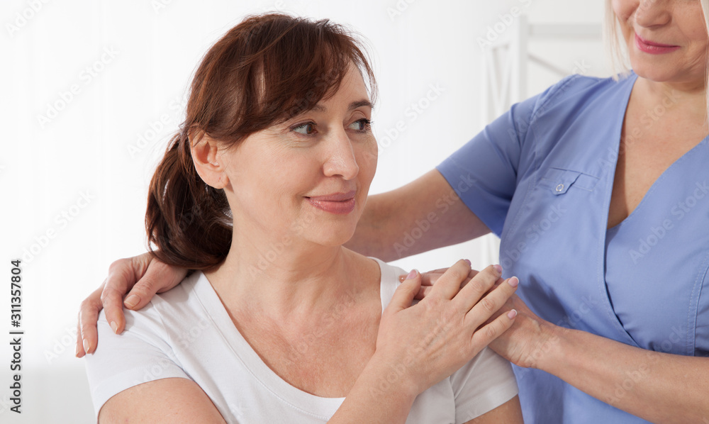 Female patient being reassured by doctor in hospital. Female patient being reassured by doctor in hospital.