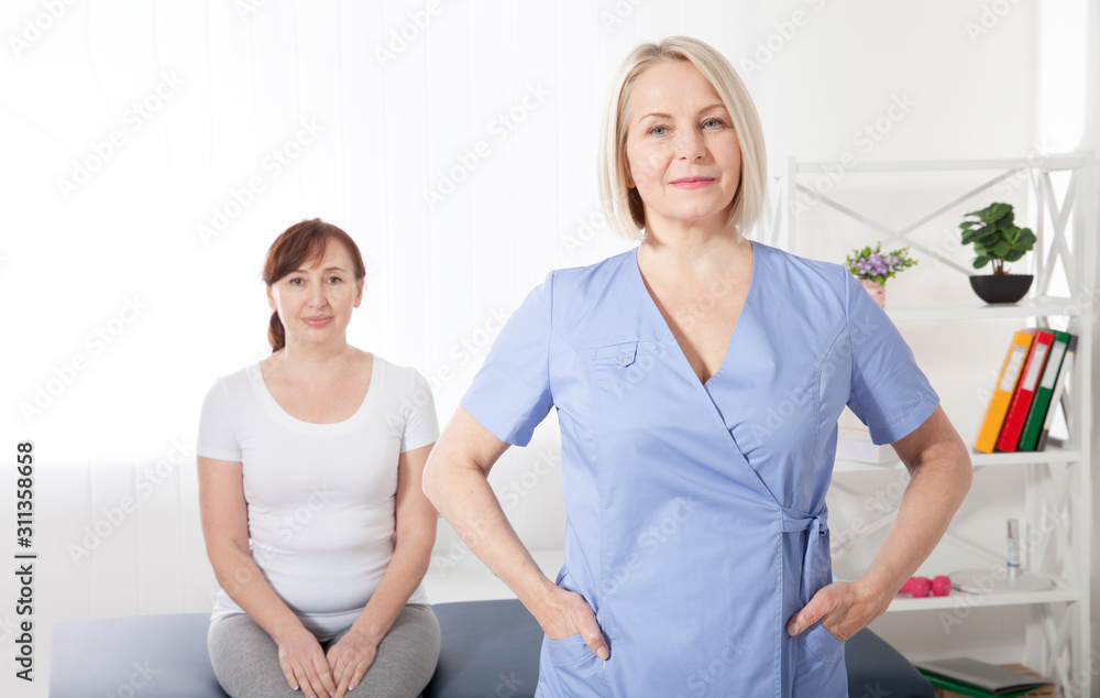 Fototapeta premium Physiotherapist smiling at camera in medical office