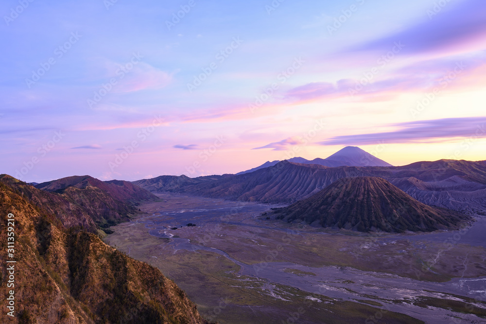 View from above, stunning aerial view of the Mount Batok, Mount Bromo and the Mount Semeru in the distance during a beautiful sunrise. Mount Bromo is an active volcano in East Java, Indonesia.