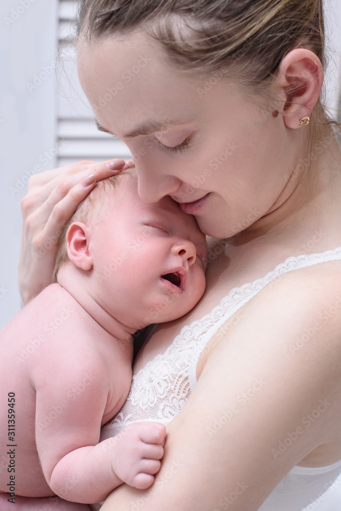 Mother with a blond sleeping baby in her arms, a moment of tenderness. Close-up Mother with a blond sleeping baby in her arms, a moment of tenderness. Close-up