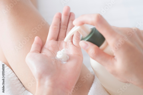Woman applying moisturizing cream lotion on hands  beauty concept..