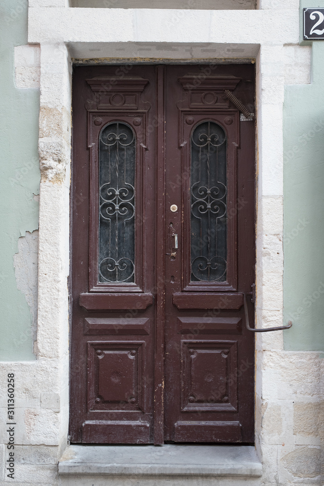 Fototapeta premium Vintage brown wooden door with forging elements.