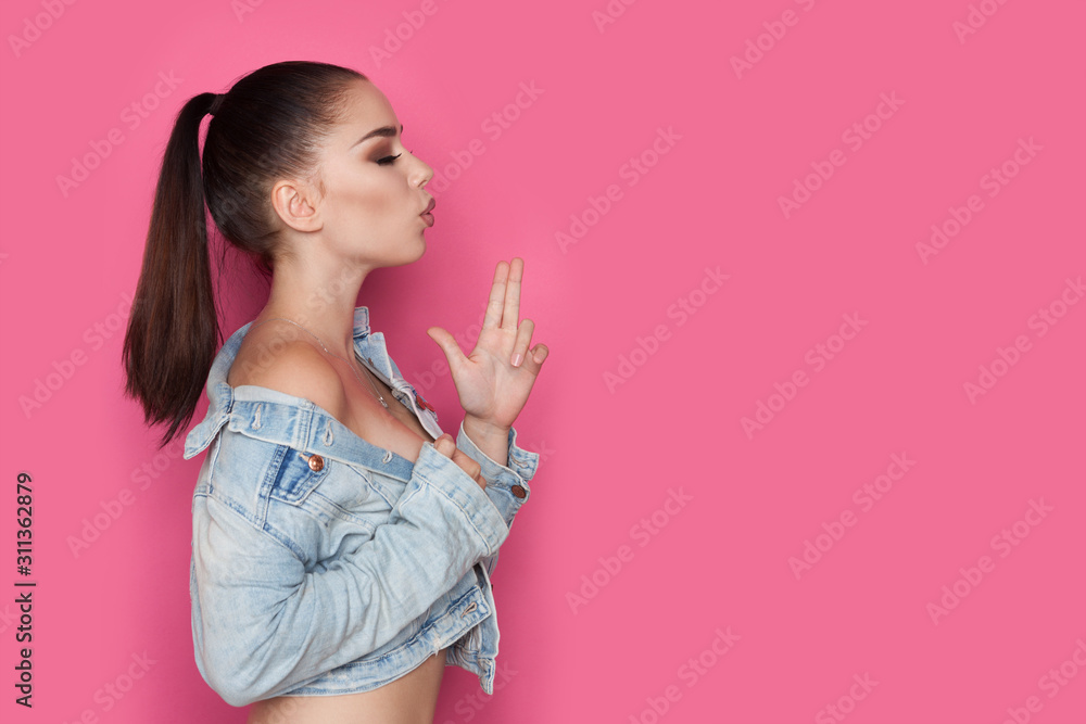 Profle View Of Young Woman Blowing On Finger Gun Profle View Of Young Woman Blowing On Finger Gun