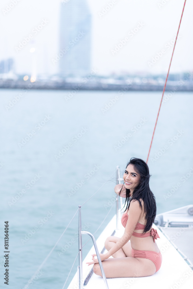 Sexy Asian woman in a bikini on a yacht, summer concept