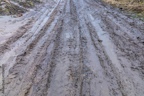 The bad ground or soil rural or suburb road or way with puddles, pools, mud and slush