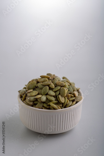 Dry pumpkin seeds in a small cup