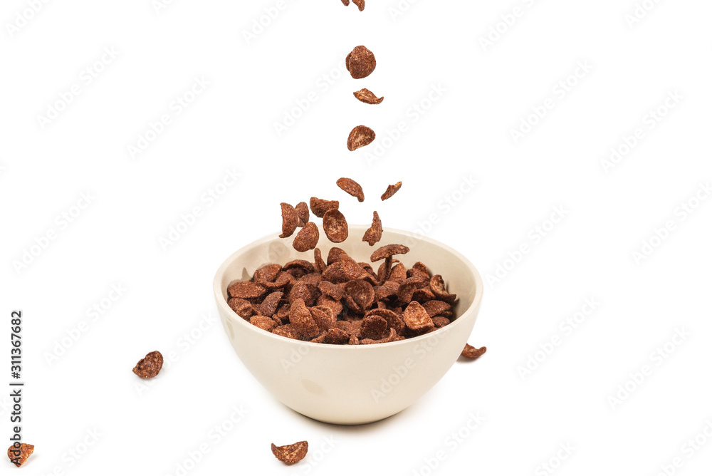Chocolate corn flakes falling to the white bowl isolated on white. Motion. Chocolate corn flakes falling to the white bowl isolated on white. Motion.