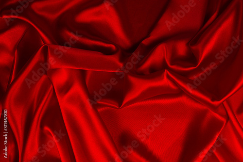 Red silk or satin luxury fabric texture can use as abstract background. Top view.