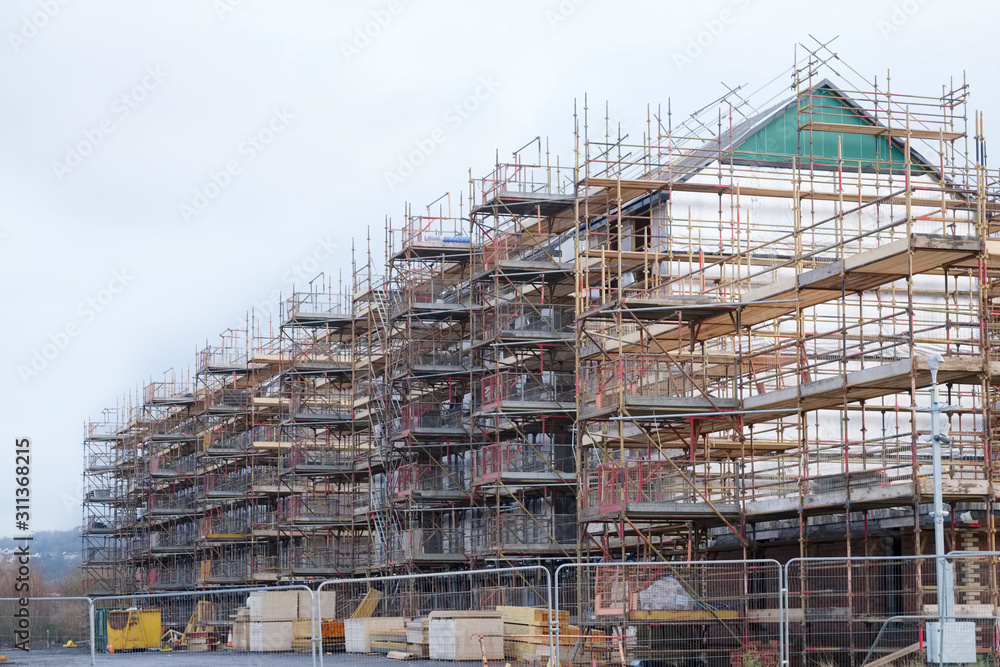 Building affordable homes with scaffolding safety by local construction council to help government social housing problem and shortage England UK