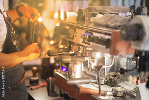 Large coffee machine in the coffee shop with blurred barista man making coffee