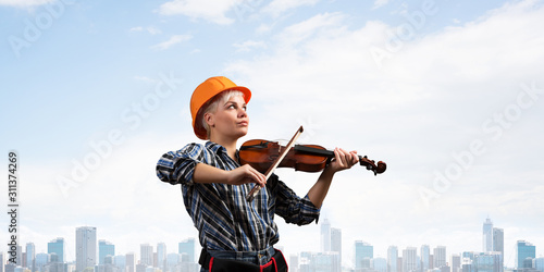 Beautiful woman in safety helmet playing violin