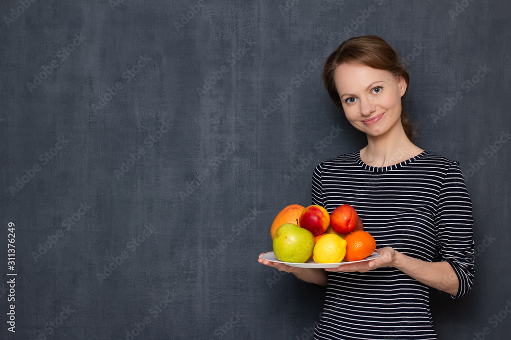 Portrait of happy girl smiling and holding plate of ripe tasty fruits Portrait of happy girl smiling and holding plate of ripe tasty fruits