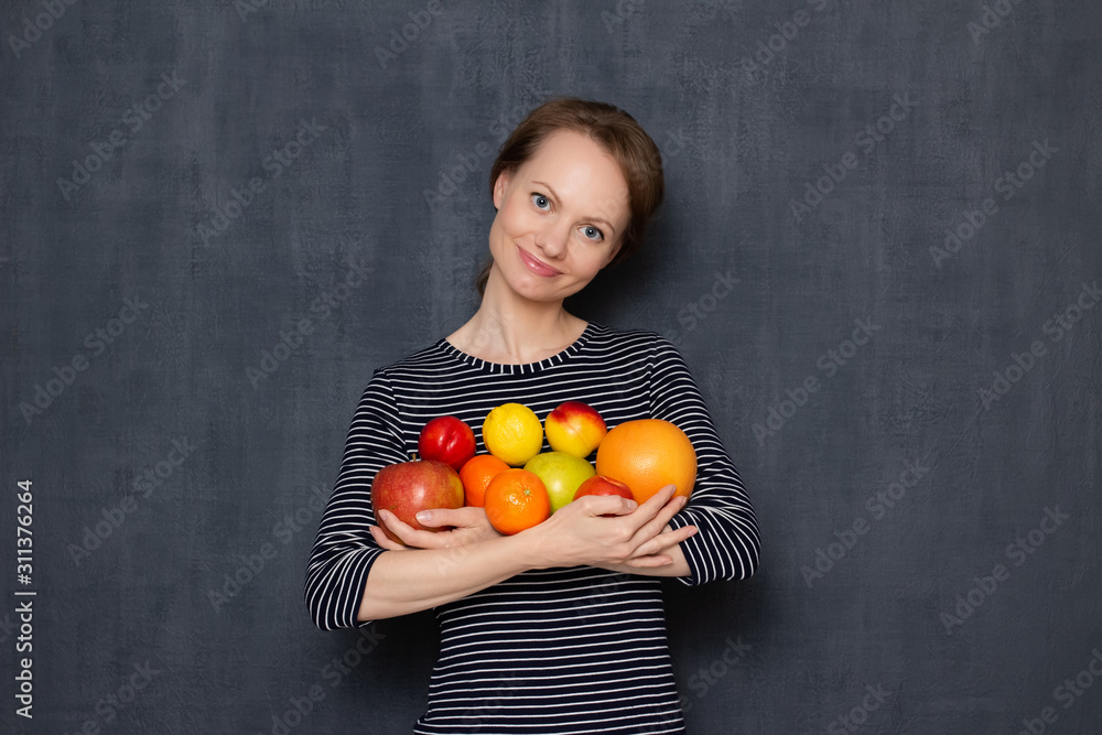 Portrait of happy positive girl smiling and holding fruits in hands Portrait of happy positive girl smiling and holding fruits in hands