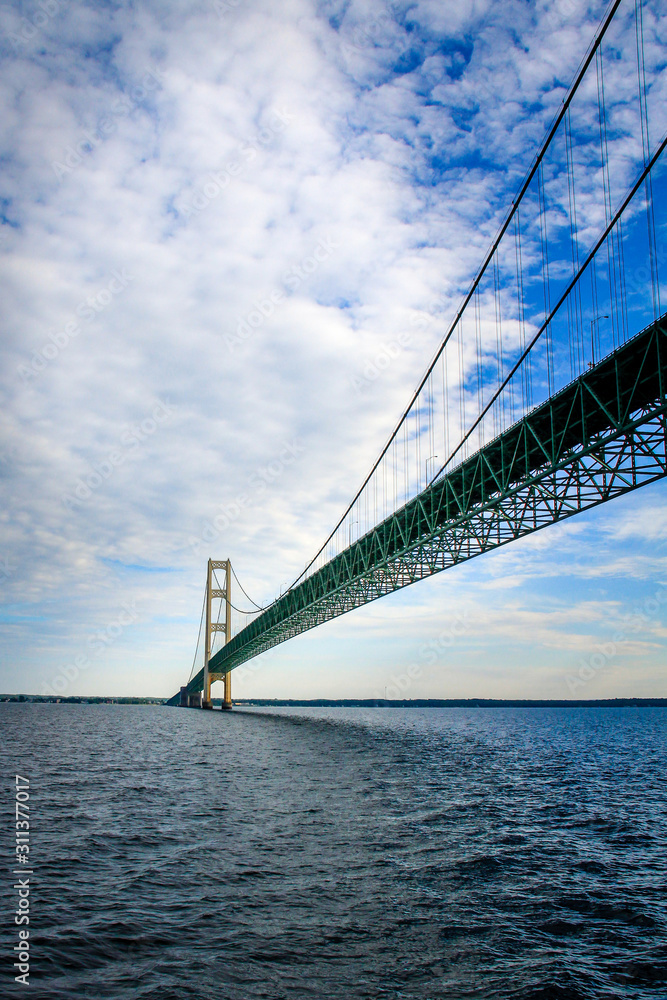 Fototapeta premium The Mackinac bridge extends to the horizon above the waters of Lake Huron and Lake Michigan.