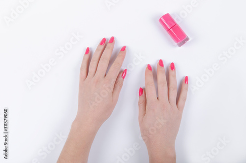 woman's hand with pink nail polish on white background