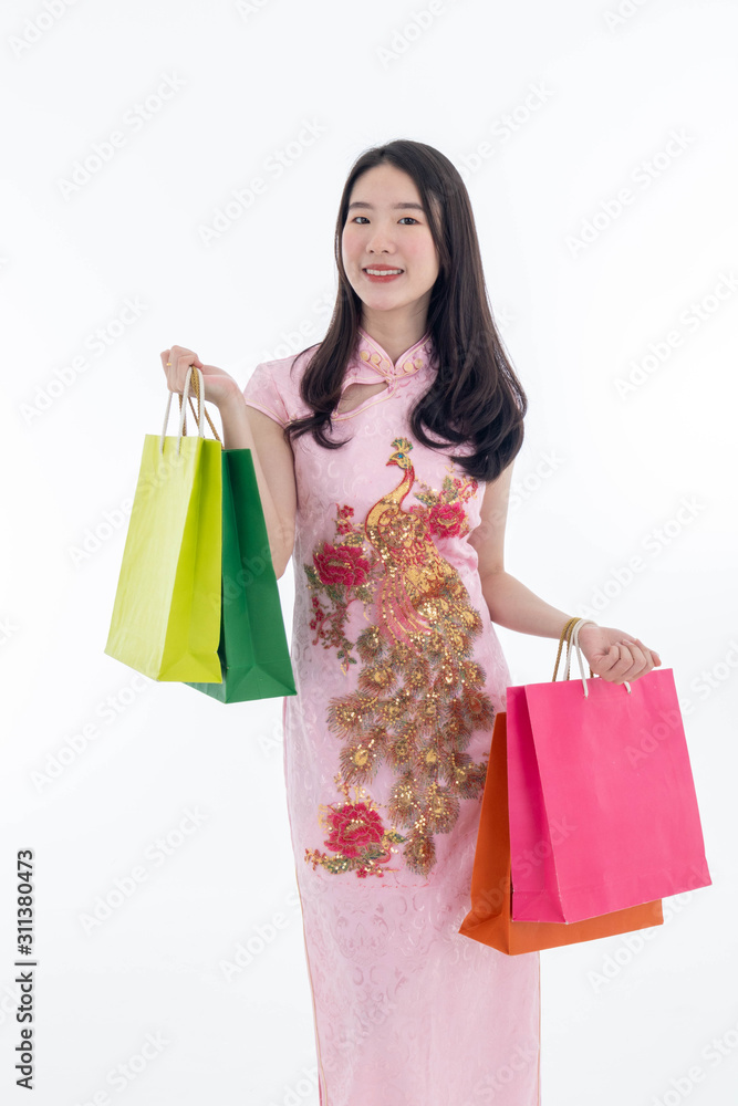 Chinese new year with Beauty smiling woman wears dresses traditional cheongsam and holds many shopping bags, studio shot isolated on white background. Chinese new year with Beauty smiling woman wears dresses traditional cheongsam and holds many shopping bags, studio shot isolated on white background.
