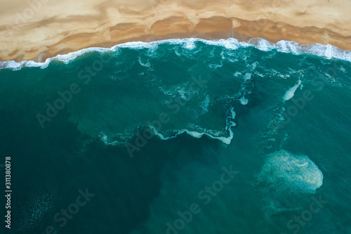Obraz na płótnie ocean and beach aerial top view, foam wave pattern w salonie