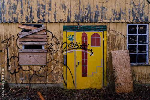 Lost Place - Stuttgart - kaputtes Gebäude mit kaputtem Fenster das verbarrikadiert ist und Graffiti an der Hauswand