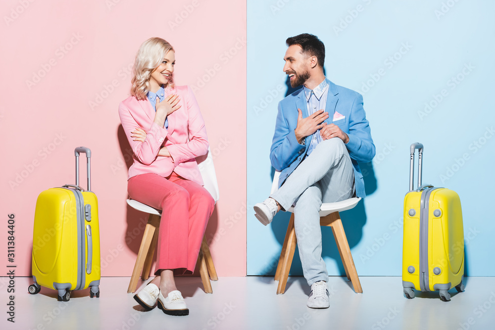 smiling woman and handsome man looking at each other on pink and blue background smiling woman and handsome man looking at each other on pink and blue background