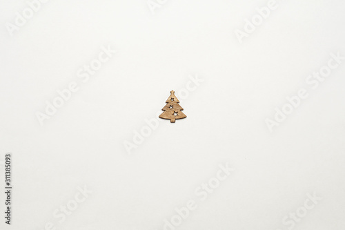 One small wooden Christmas tree with carved stars in the center on a white background