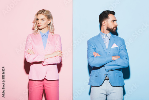 sad woman and handsome man with crossed arms on pink and blue background