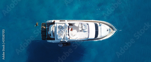 Aerial drone top down ultra wide photo of small yacht docked in tropical exotic turquoise sea