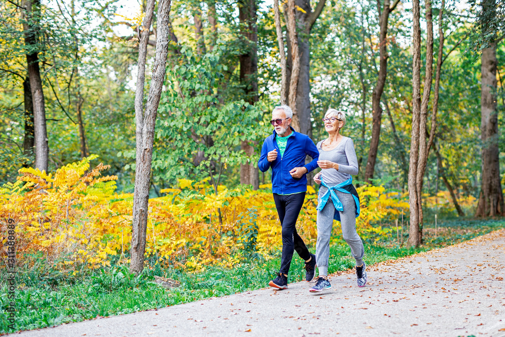 Fototapeta premium Mature couple man and woman jogging in the park